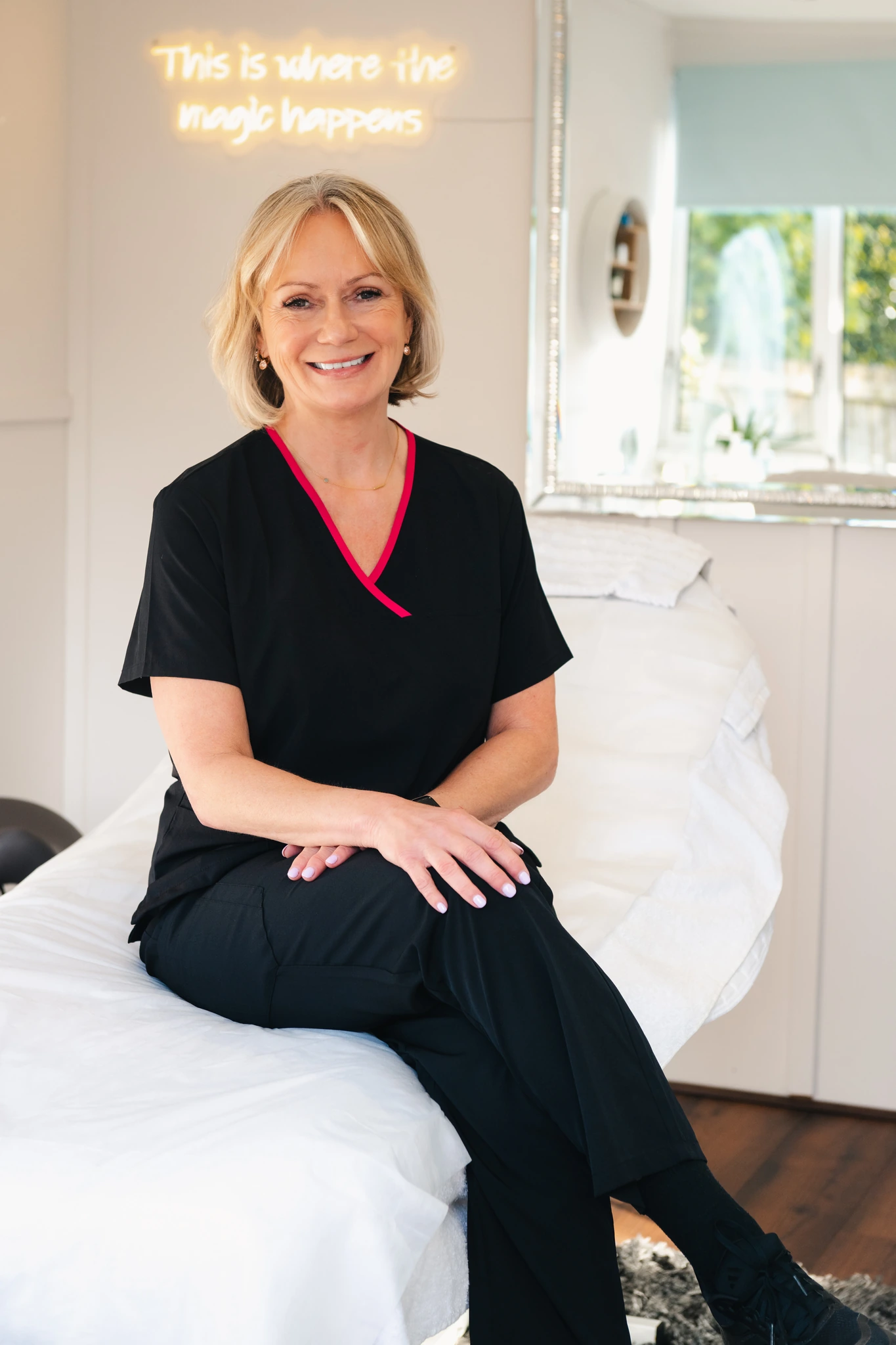a woman sitting on a massage table in a treatment room