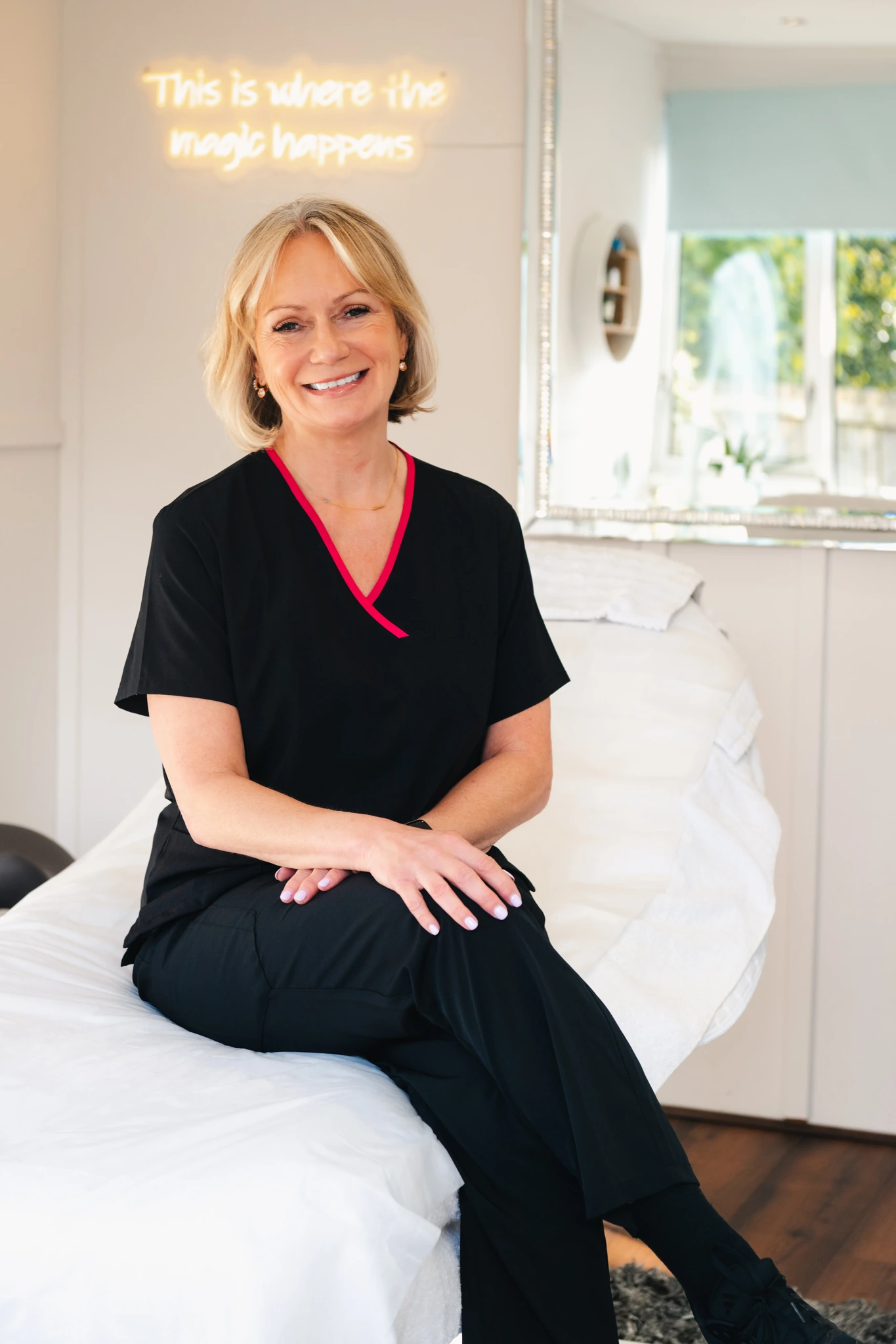 a woman sitting on a bed in a treatment room