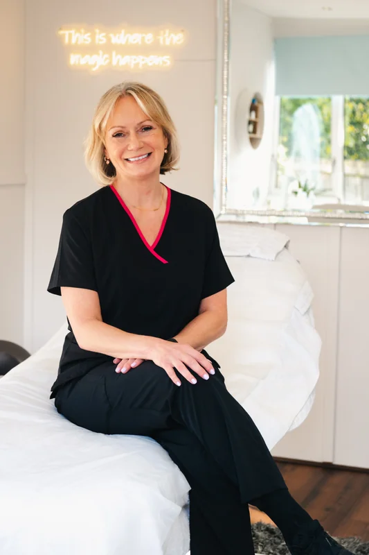 a woman sitting on a bed in a treatment room