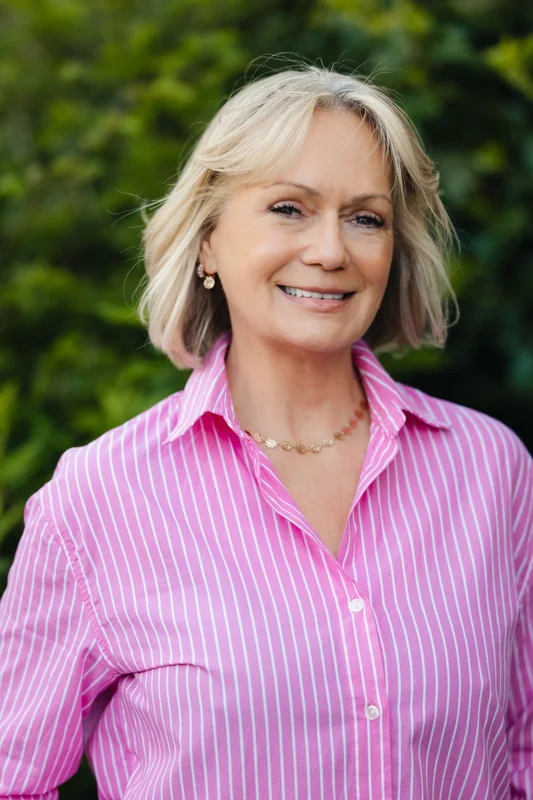 a woman in a pink shirt with a smile on her face