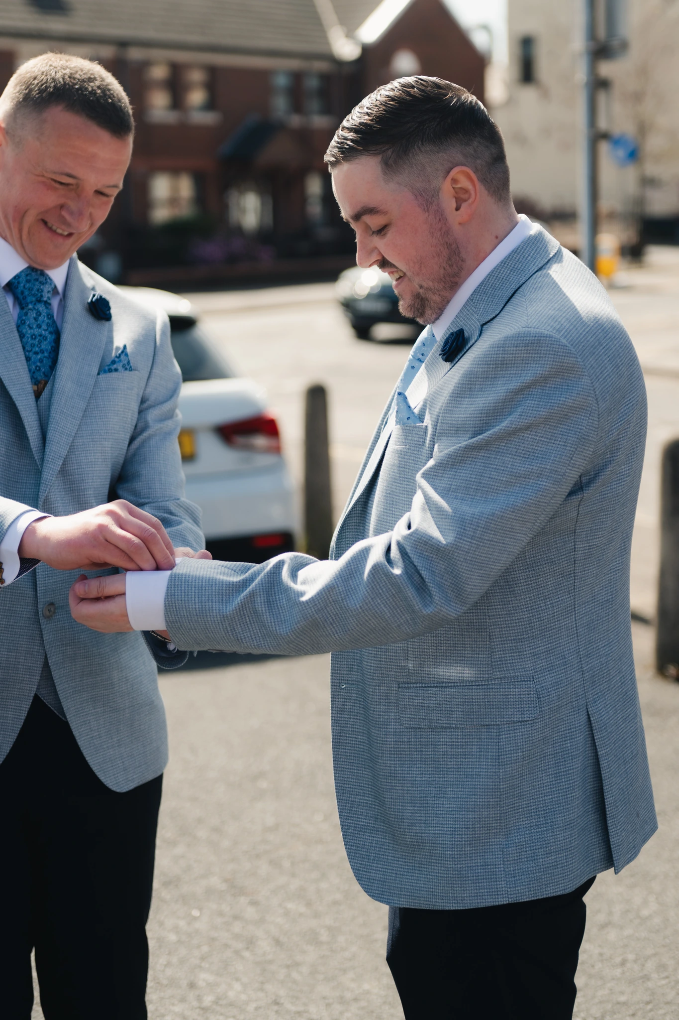 two men are standing in a street with a pair of cufflinks