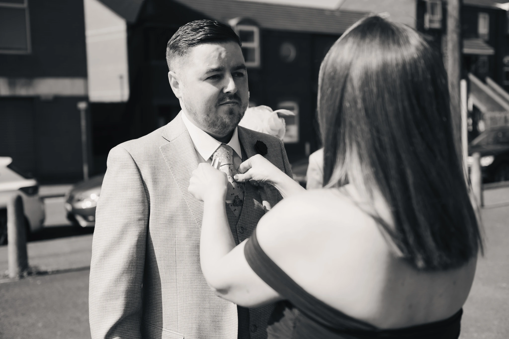 a man is putting a tie on a woman