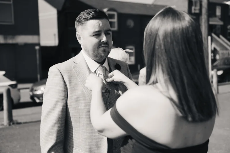 a man is putting a tie on a woman