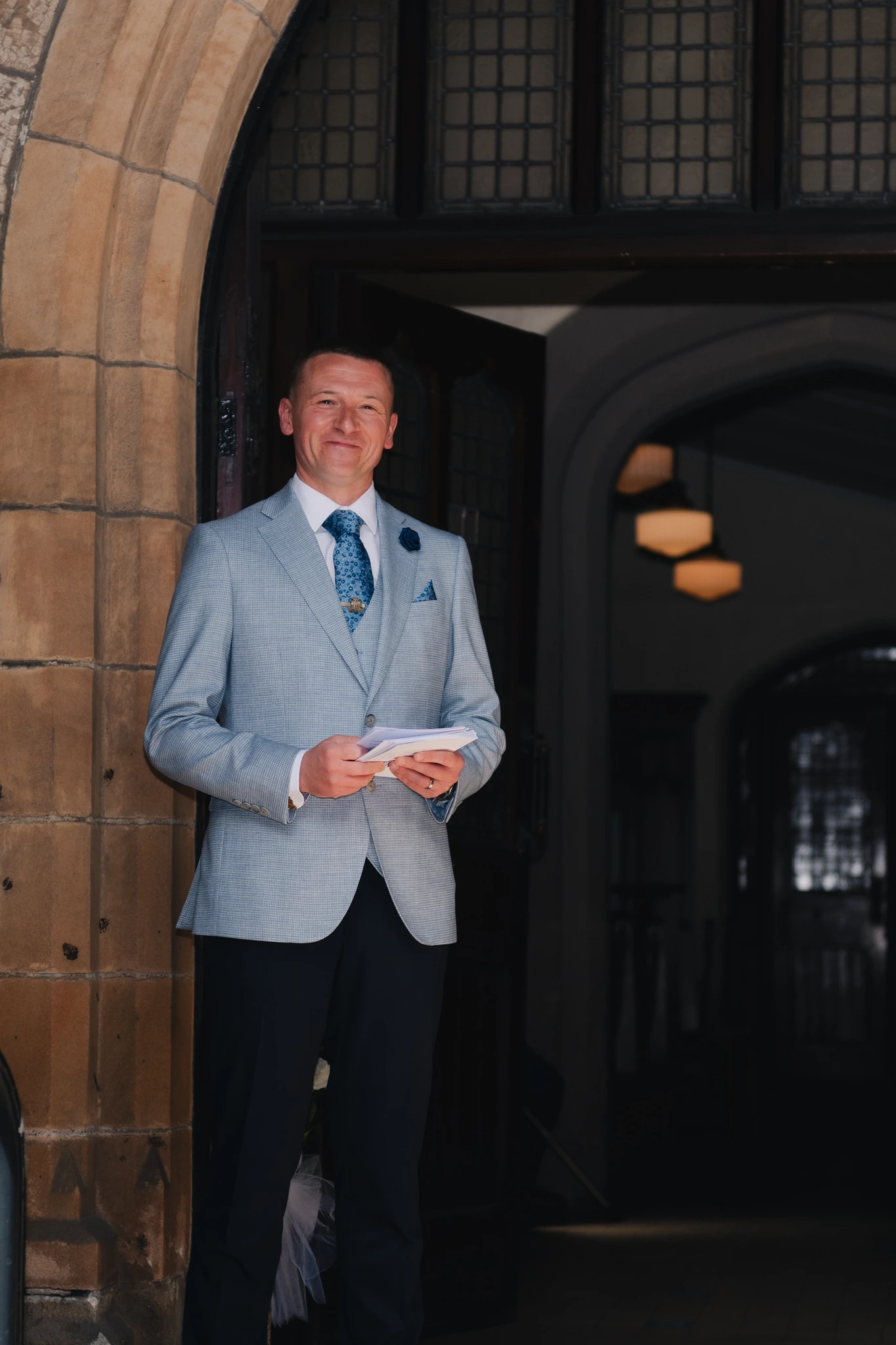 a man in a suit standing in front of a doorway