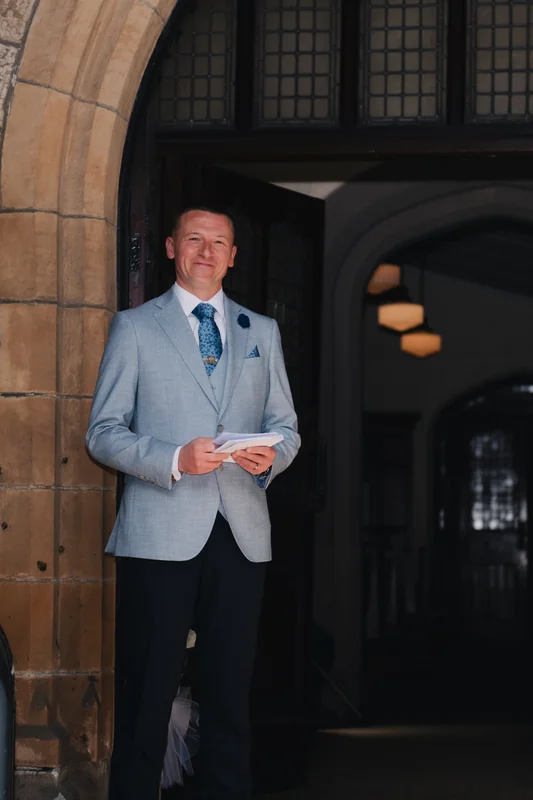 a man in a suit standing in front of a doorway