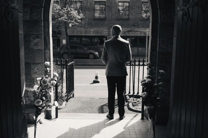 black and white photograph of a man standing in a doorway