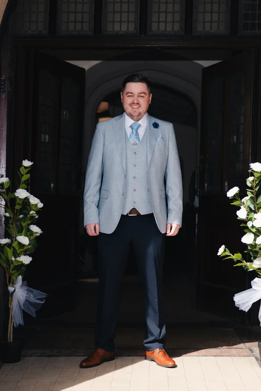 a man in a suit standing in front of a doorway