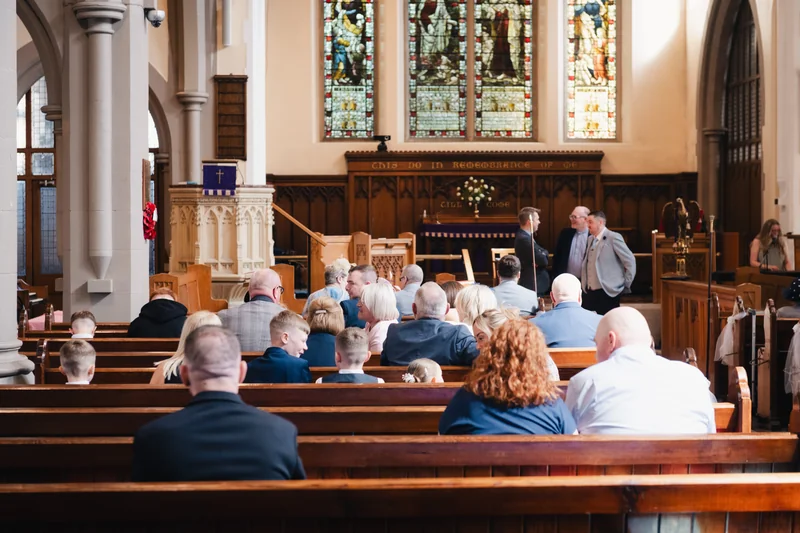 a group of people sitting on pews in a church