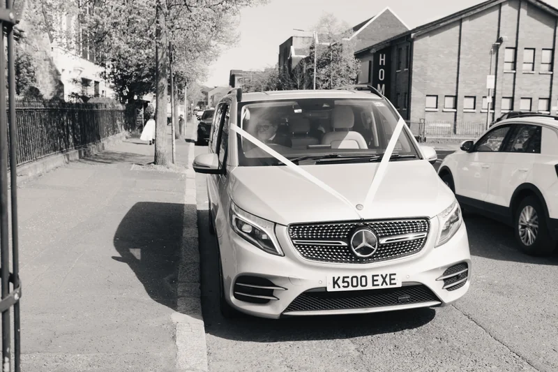 a black and white image of a mercedes benz van parked on a street