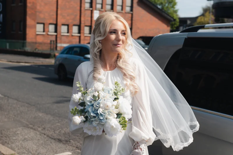 a bride walking down the street with her wedding bouquet