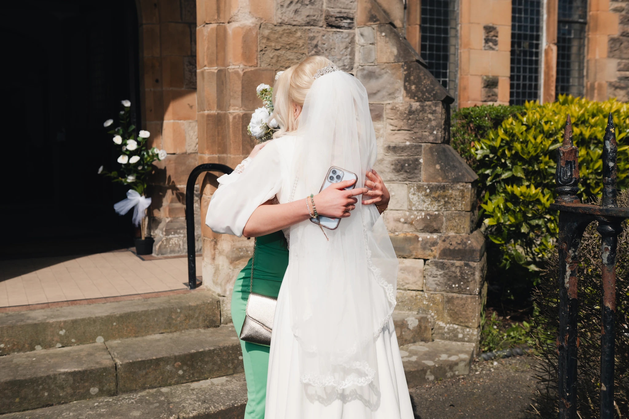 a bride and groom hugging in front of a church