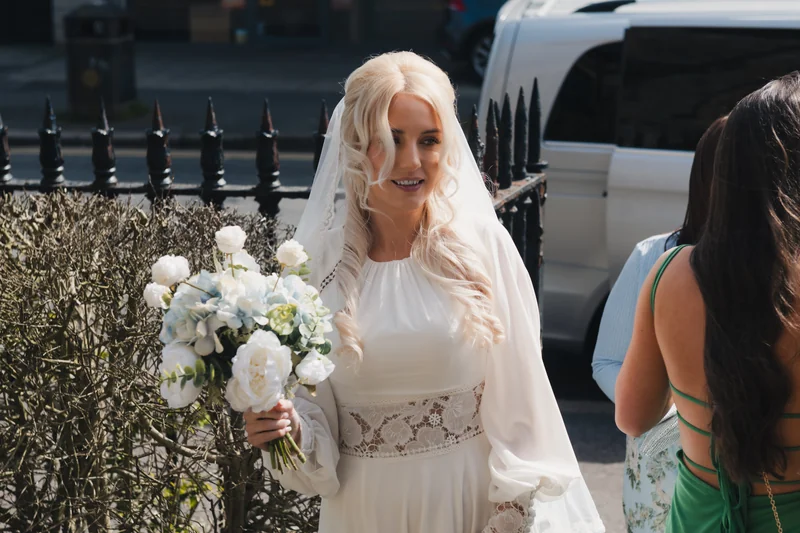 a bride walks down the street with her bridesmaid