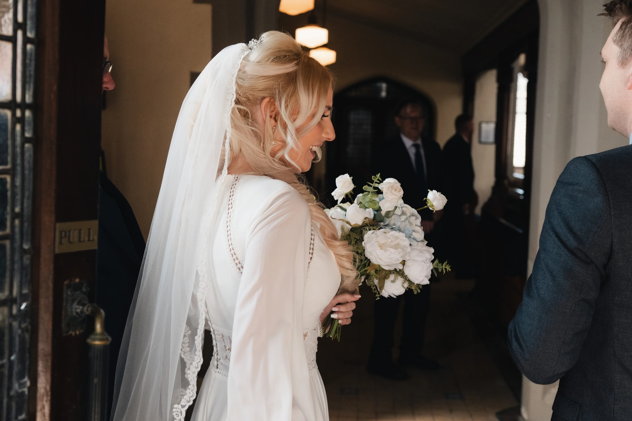 a bride and groom look at each other as they walk down the aisle