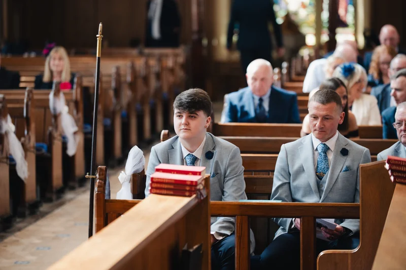 a wedding ceremony in a church with a bride and groom sitting on the pews