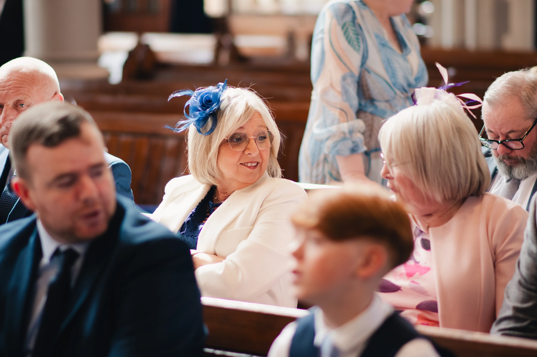 a bride and groom look at each other as they walk down the aisle