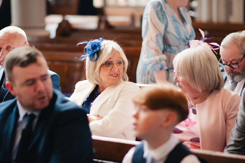 a bride and groom look at each other as they walk down the aisle