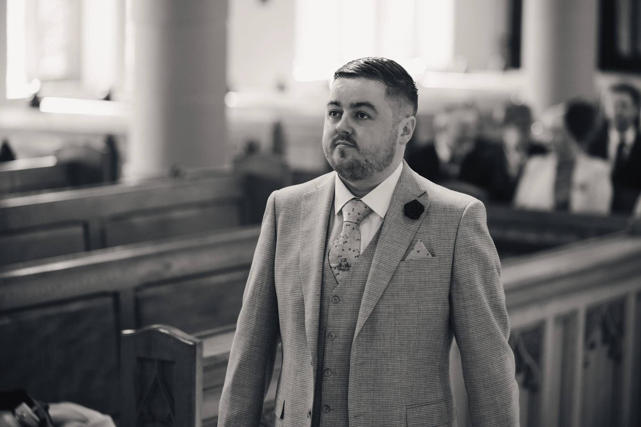 a man in a suit walking down the aisle of a church
