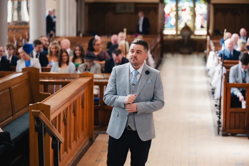 a man walking down the aisle of a church