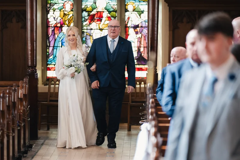 a bride walks down the aisle of a church