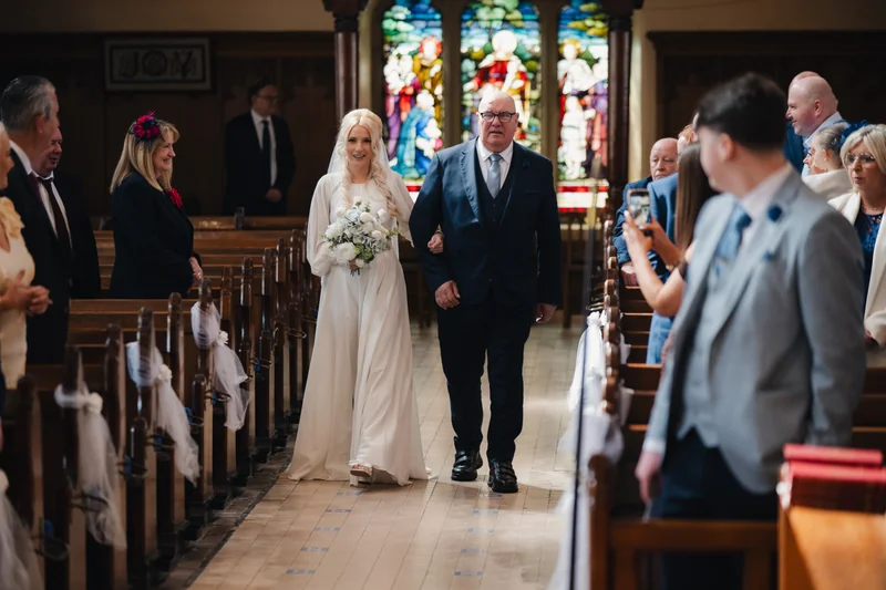 a bride walks down the aisle of a church