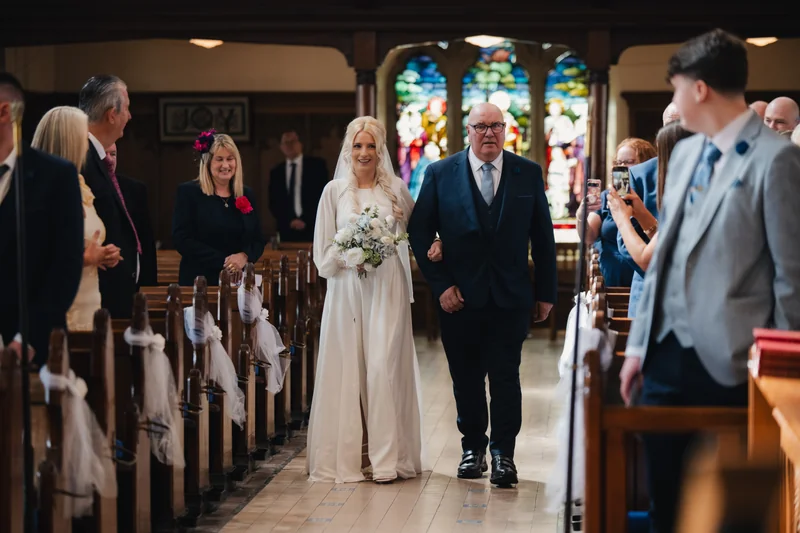 a bride walks down the aisle of a church