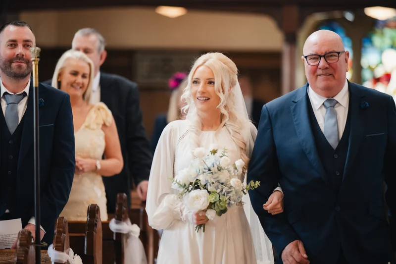 a bride walks down the aisle of a church