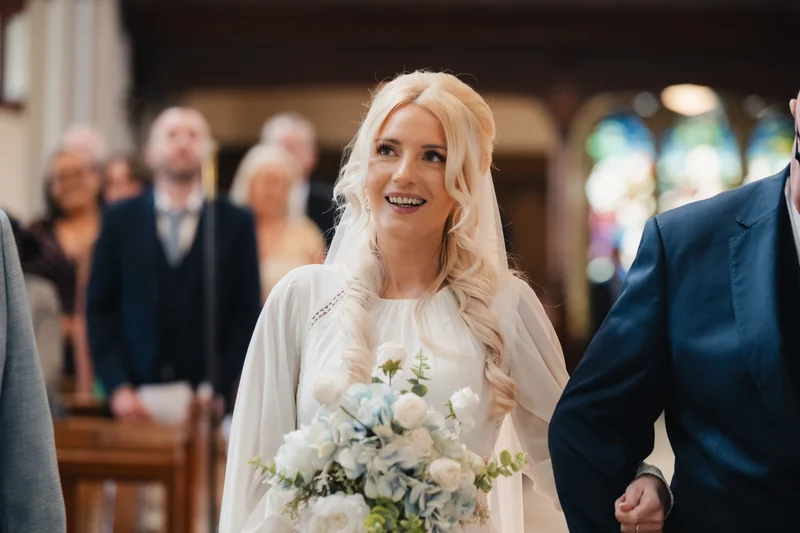 a bride walks down the aisle of a church