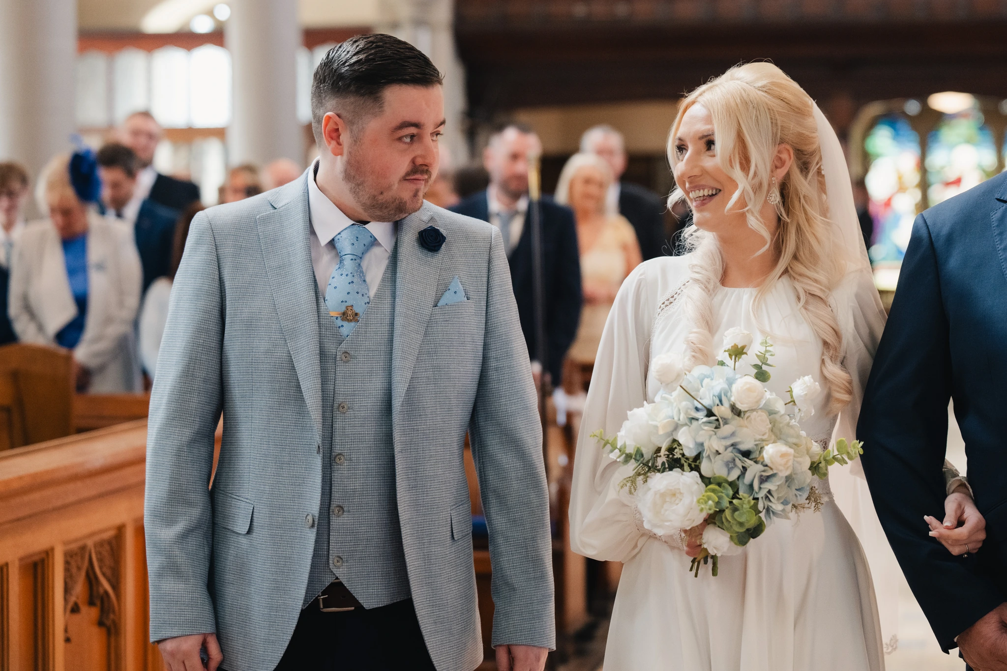 a bride and groom walk down the aisle of a church
