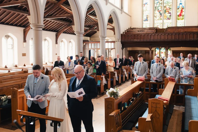 a bride and groom walk down the aisle of a church