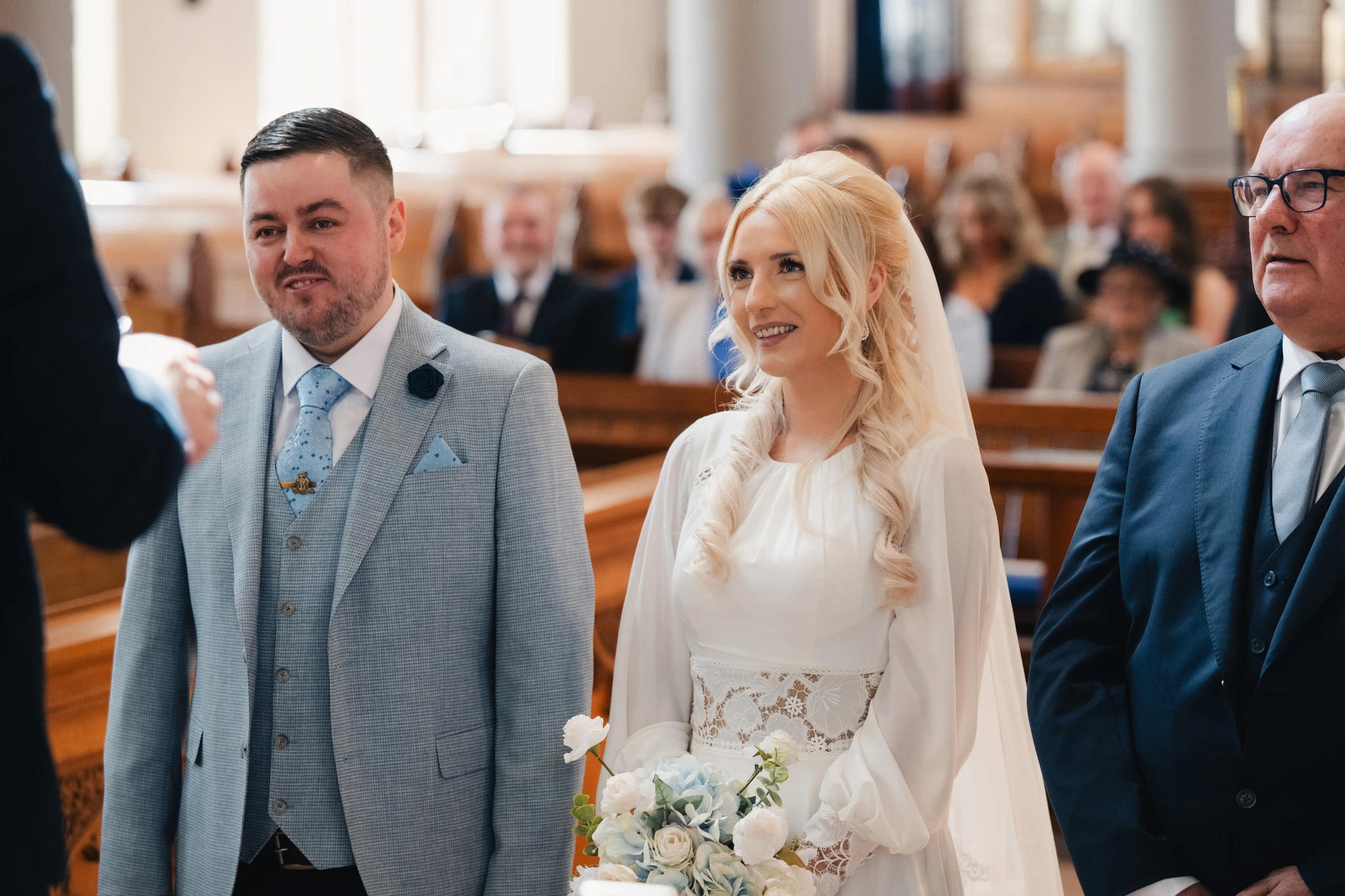a bride and groom look at each other as they walk down the aisle