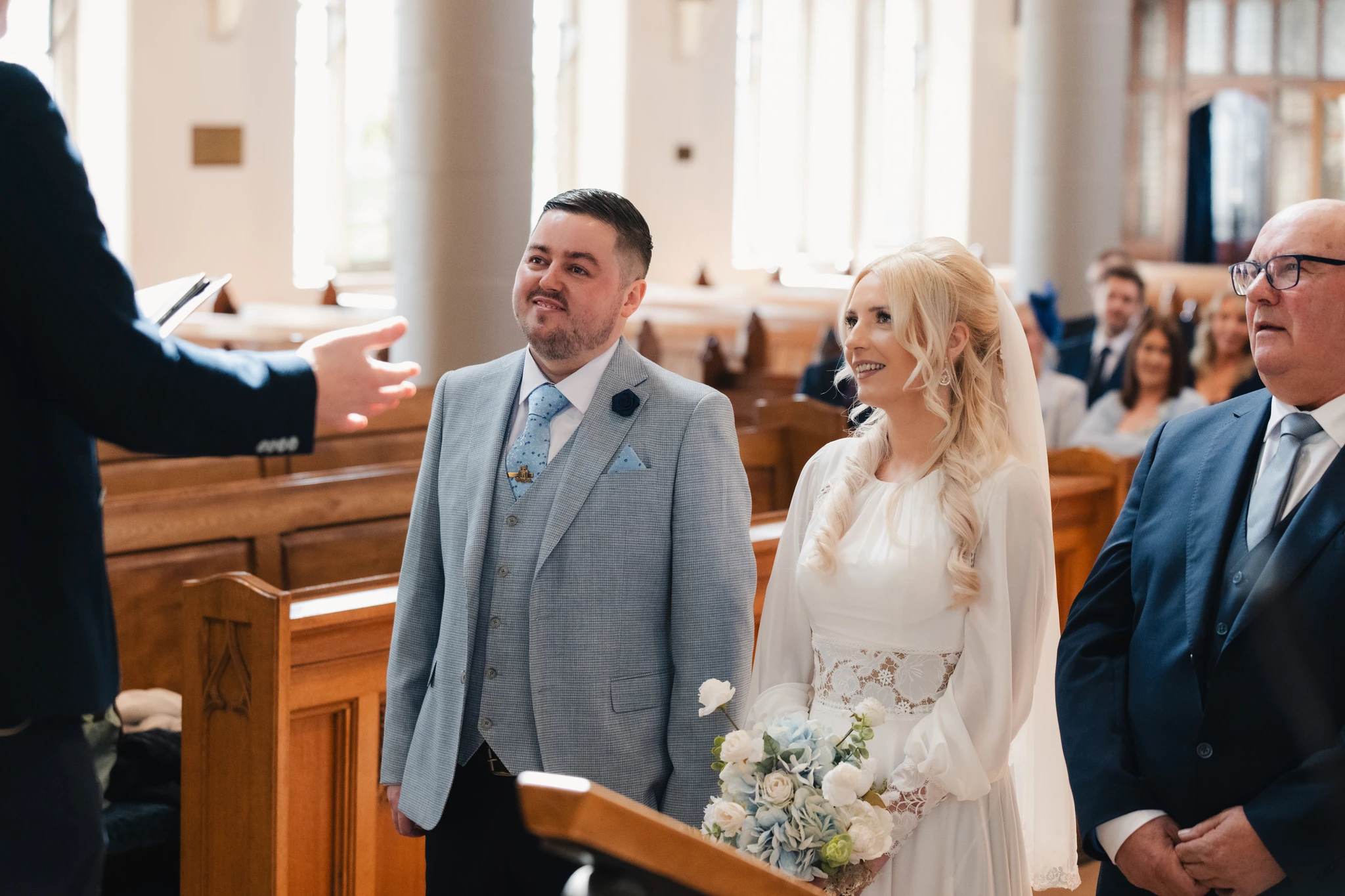 a bride and groom look at each other as they walk down the aisle