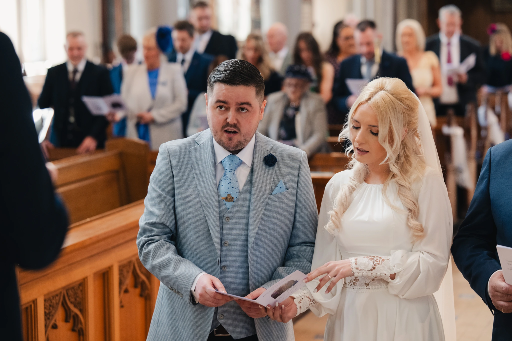 a bride and groom kiss in a church during their wedding ceremony