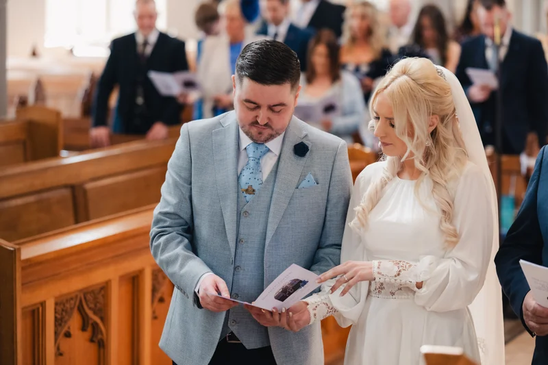 a bride and groom read their wedding vows in a church
