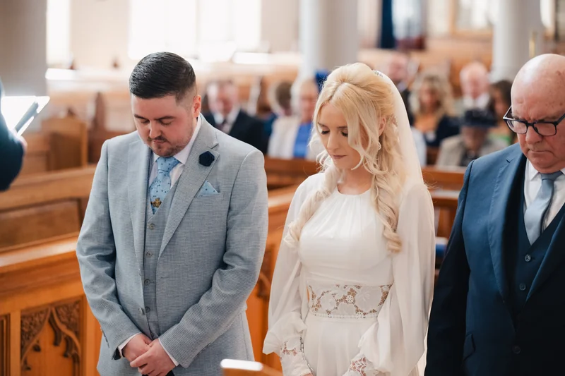 a bride and groom walk down the aisle of a church
