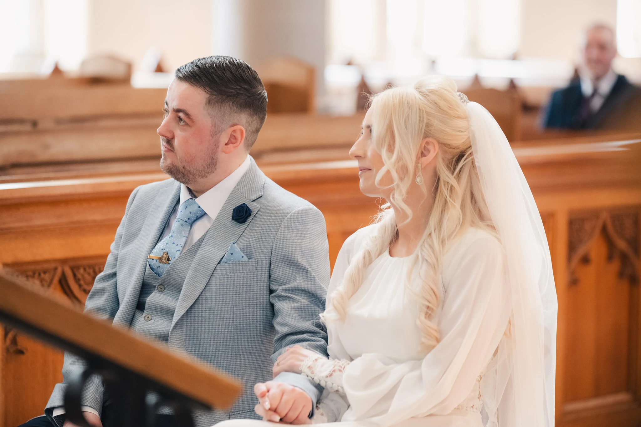 a bride and groom look at each other as they walk down the aisle