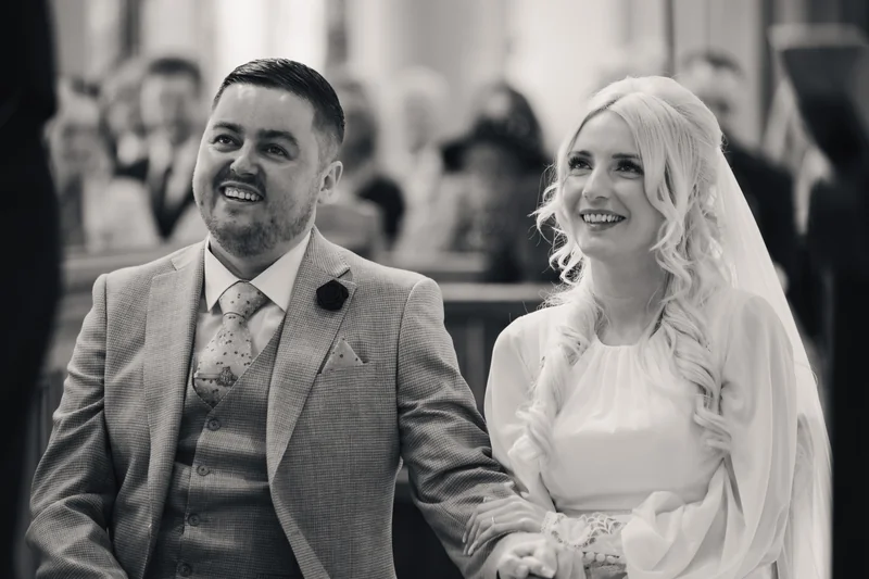 a bride and groom walk down the aisle of a church