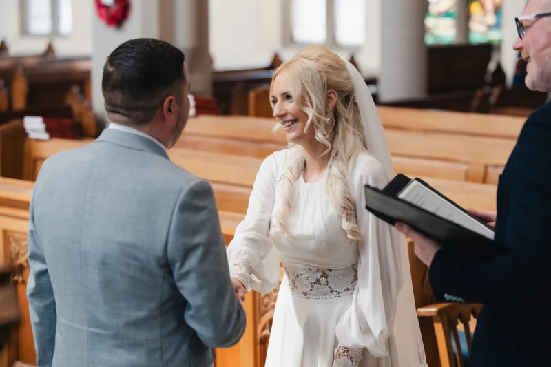 a bride and groom kissing in a church