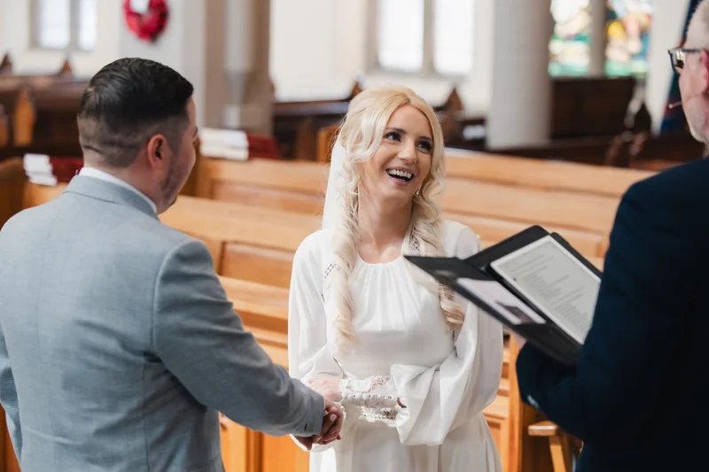 a bride and groom kiss in front of a church during their wedding ceremony