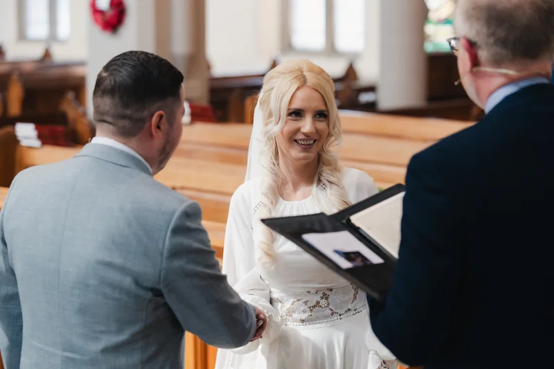 a bride and groom kissing in front of a church during their wedding ceremony