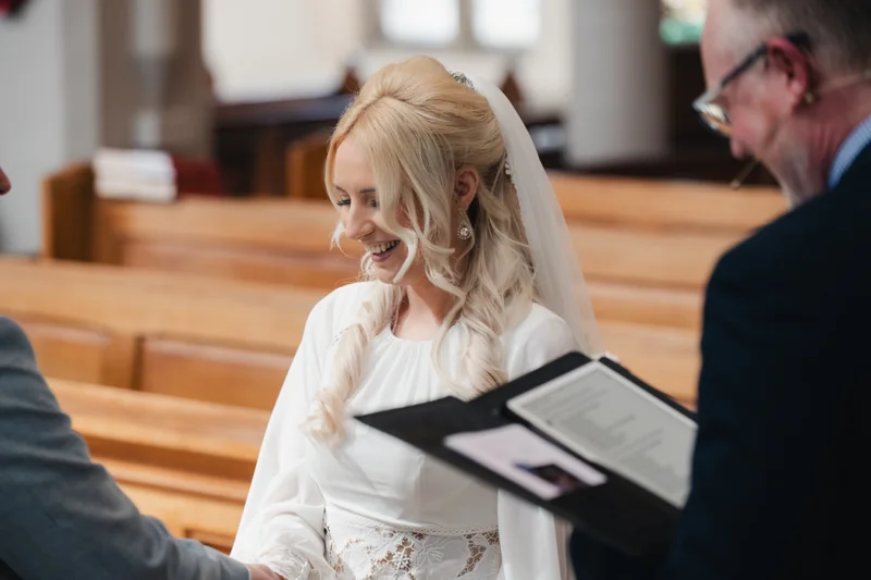 a bride and groom kissing in a church during their wedding ceremony