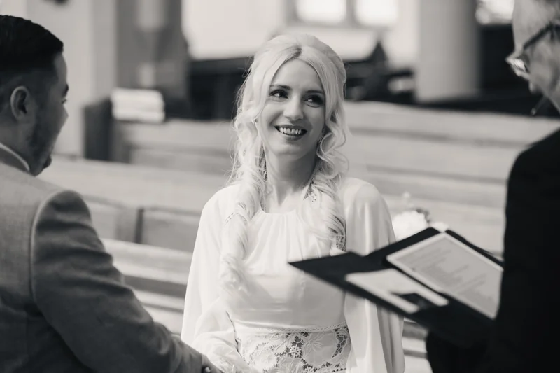 a bride and groom kiss in front of their wedding guests at a church wedding ceremony