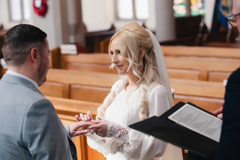 a bride and groom exchange their wedding rings in a church