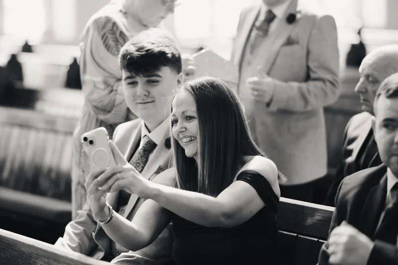 a bride and groom taking a selfie in a church