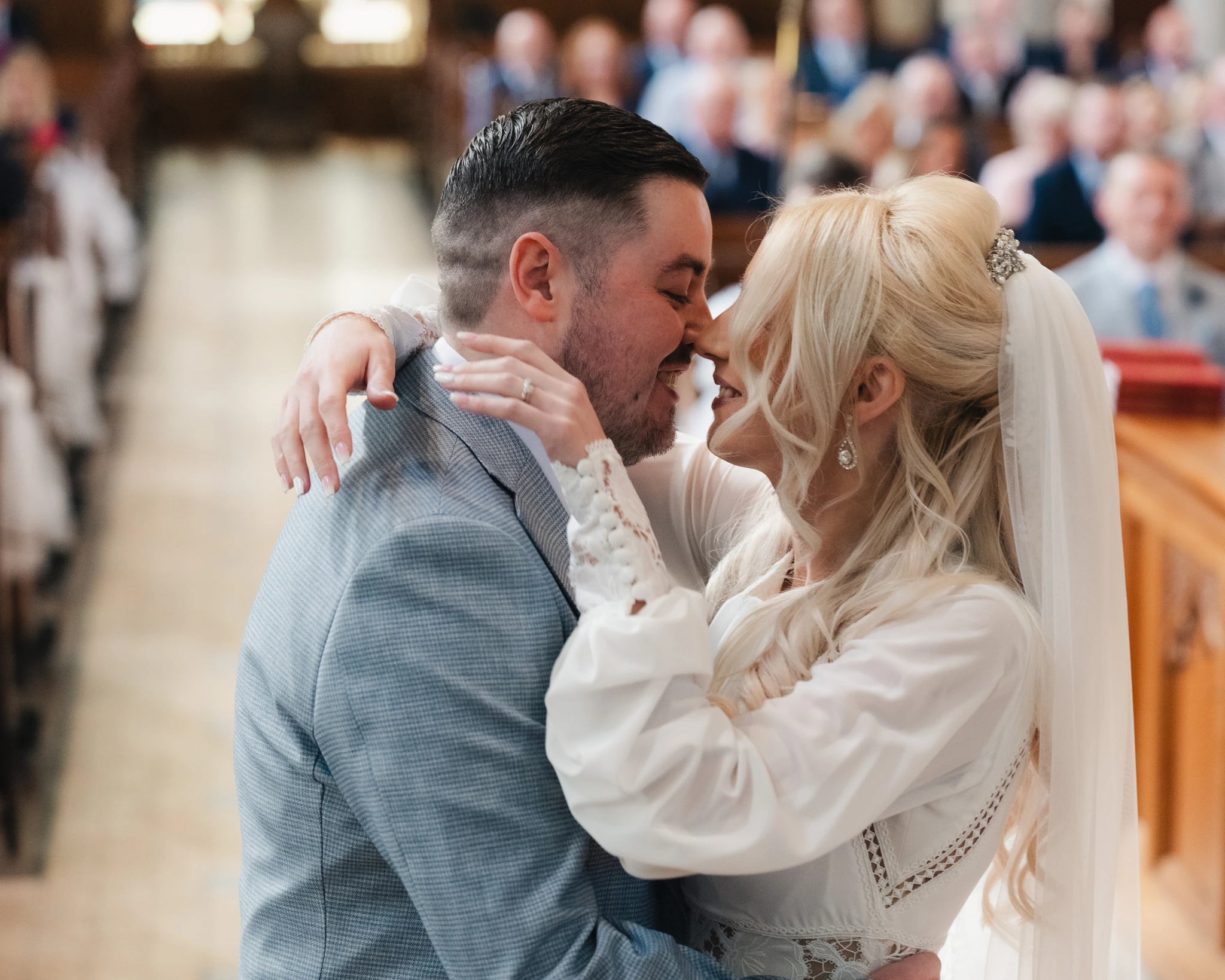 a bride and groom kiss during their wedding ceremony in a church