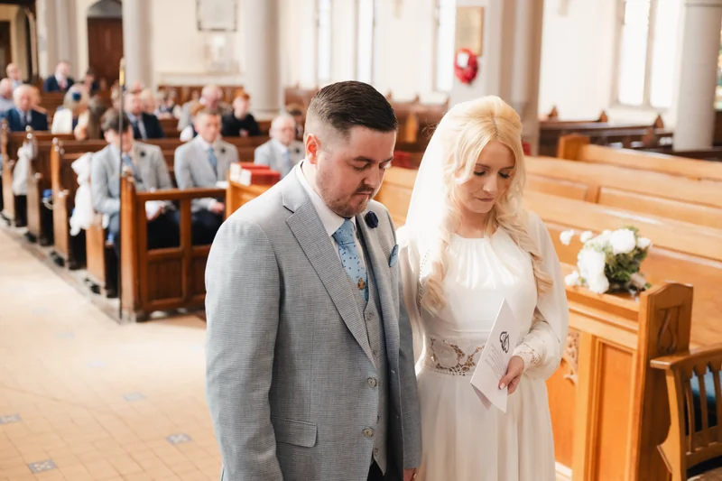 a bride and groom walk down the aisle of a church