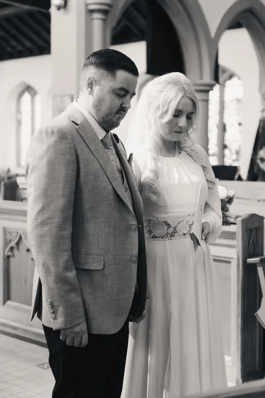 a bride and groom look at each other as they walk down the aisle