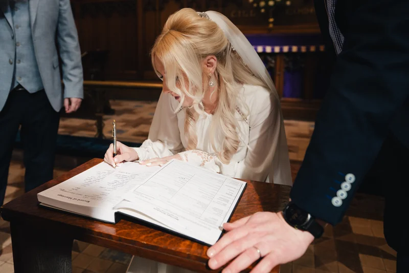 a bride and groom sign their wedding vows in a church
