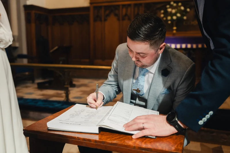 a bride and groom signing their wedding vows in a church