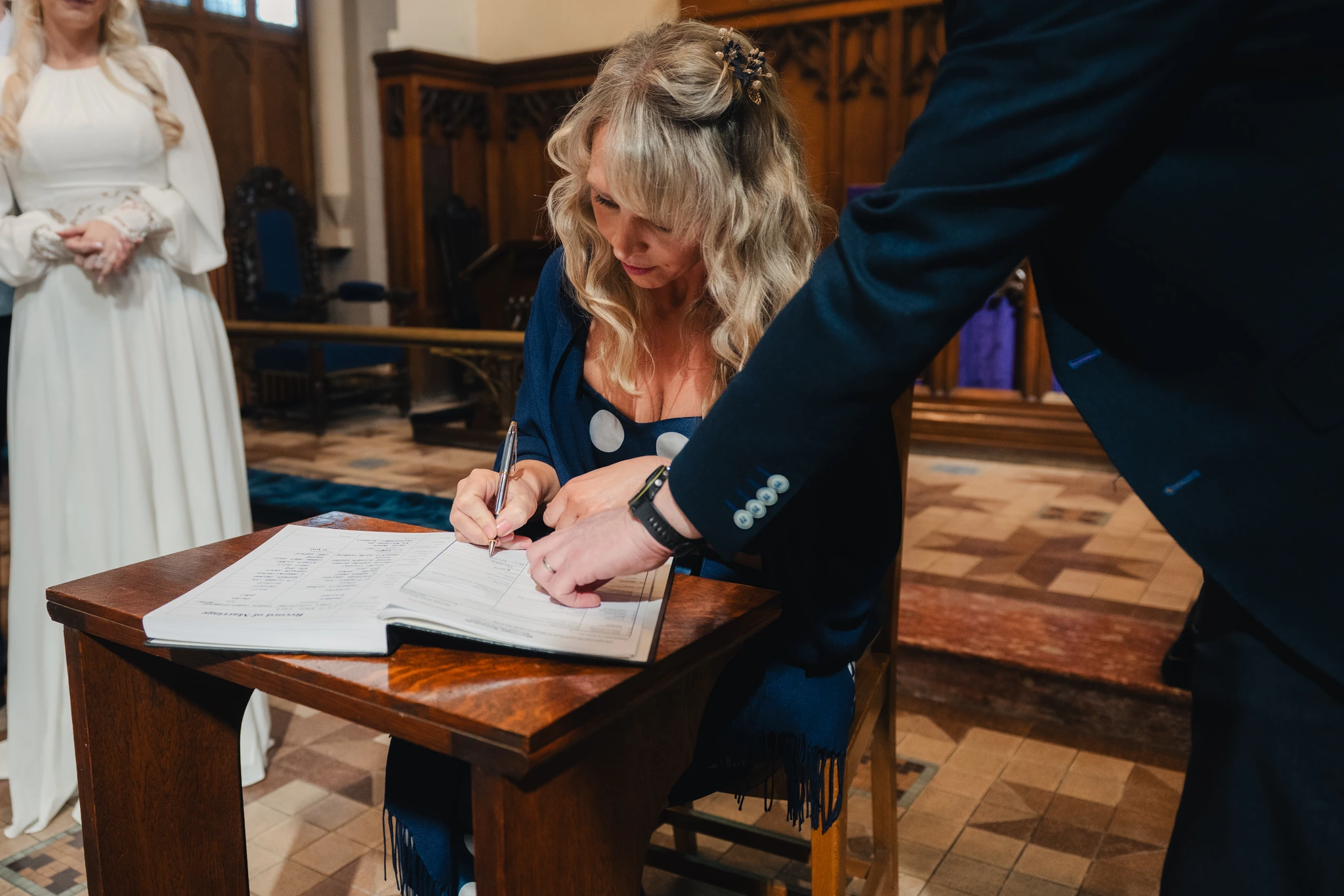 a bride and groom signing a wedding book in a church