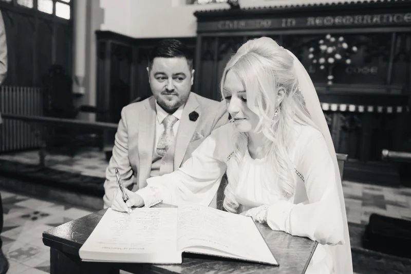 a bride and groom sign their wedding vows in a church